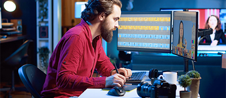 Sound and video editor intently reviewing image on monitor while typing on keyboard during live broadcast. 