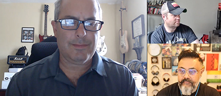 A video call grid with three participants in home settings. One larger panel on the left shows a person in glasses and a dark shirt in a room with guitars on the wall; two smaller panels on the right show a person in a cap and a person with a beard, each in their own room.